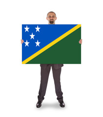 Smiling businessman holding a big card or flag
