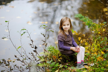 Adorable little girl playing by a river