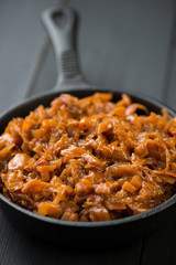 Cast-iron frying pan with stewed cabbage, vertical shot
