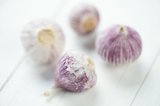 Close-up of chinese garlic bulbs, white wooden background