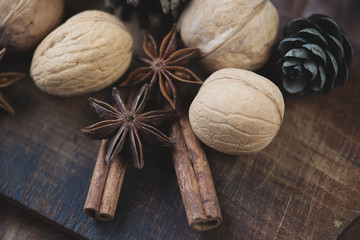 Rustic cutting board with walnuts, cinnamon sticks and anise
