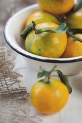 Naklejka na ściany i meble Close-up of an enameled bowl with mandarins, vertical shot
