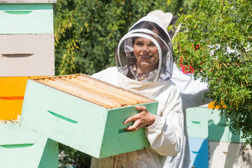 Portrait Of Beekeeper Working At Apiary