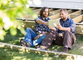 Carpenters Using Digital Tablet At Construction Site