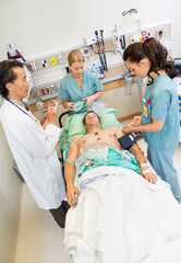 Nurses And Doctor Examining Critical Male Patient