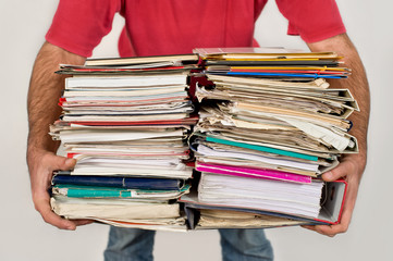 Man with a bunch of old newspapers in the hands