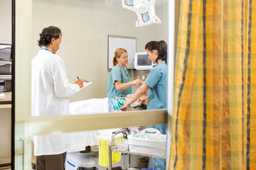 Nurses And Doctor Examining In Patient