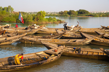 fisher men working in their boat on the Niger River - obrazy, fototapety, plakaty