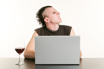 portrait of young man in punk style to your computer, angry