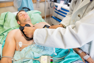 Doctor Defibrillating Patient In Emergency