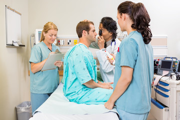 Medical Team Examining Patient In Hospital