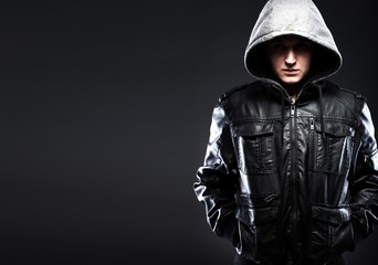 Fototapeta na wymiar Scary hooligan man in leather jacket with a hood