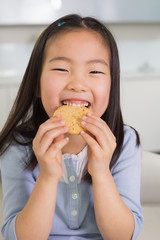 Portrait of a smiling young girl enjoying cookies