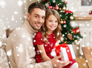 smiling father and daughter holding gift box