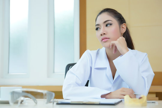 Bored woman dentist looking very boring at her desk