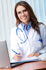 Cheerful female doctor with laptop