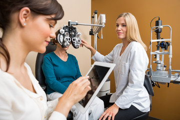 Eye Doctors Examining Senior Woman In Store