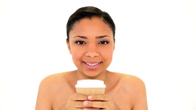 Content calm woman holding a disposable cup smelling it