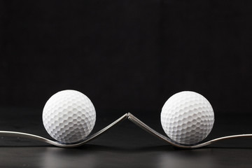 Golf balls on the black background