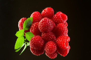 Fresh organic ripe raspberries on black background