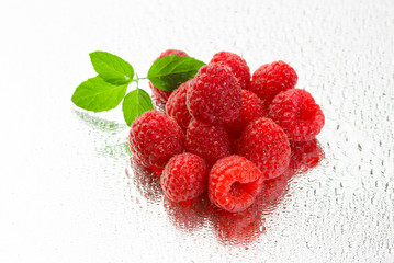Fresh organic ripe raspberries under rain on white background