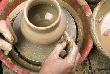 hands of a potter, creating an earthen jar on the circle