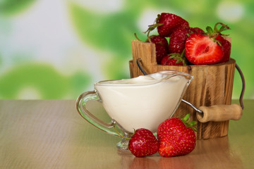 Strawberry in bucket and cup with cream