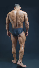 Fototapeta na wymiar Full back figure of muscular bodybuilder