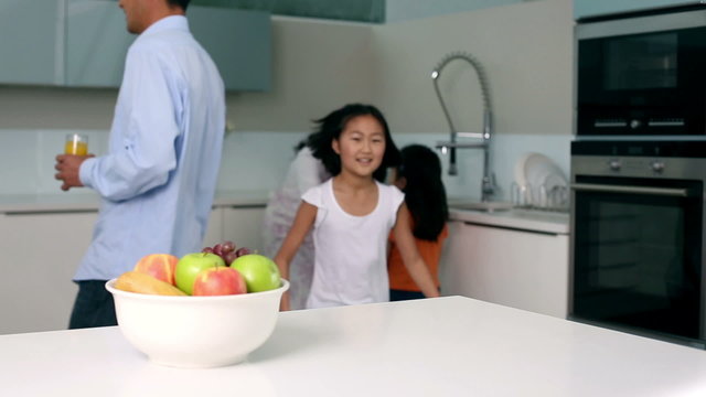 Little girl taking apple out of bowl