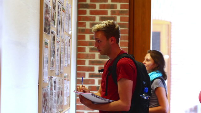 Student checking the notice board carefully