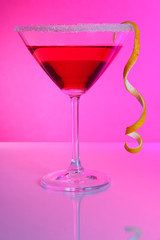 Red cocktail in martini glass  on pink background