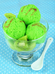 Delicious ice cream on glass vase on blue tablecloth