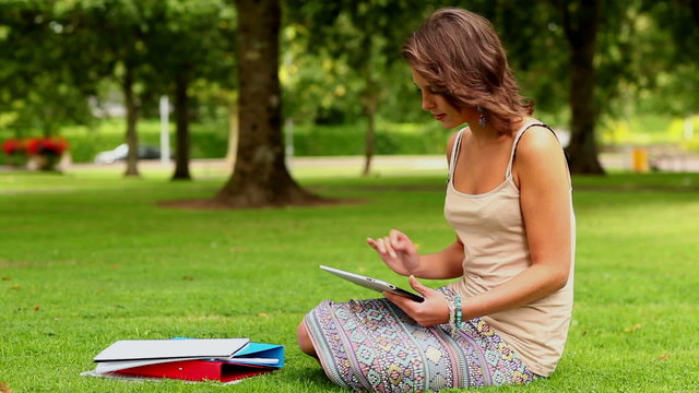 Pretty student using tablet pc outside