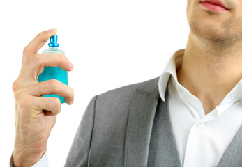 Handsome young man using perfume isolated on white