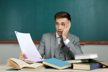 Young teacher sitting in school classroom