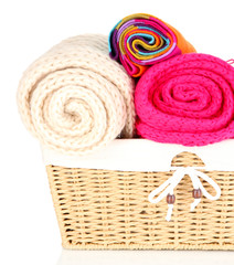 Obraz na płótnie Canvas Warm knitted scarves in basket isolated on white