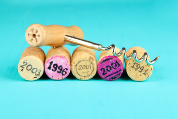 Wine corks with corkscrew on wooden table close-up