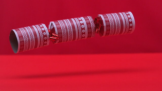 Christmas cracker dropping and bouncing on red background