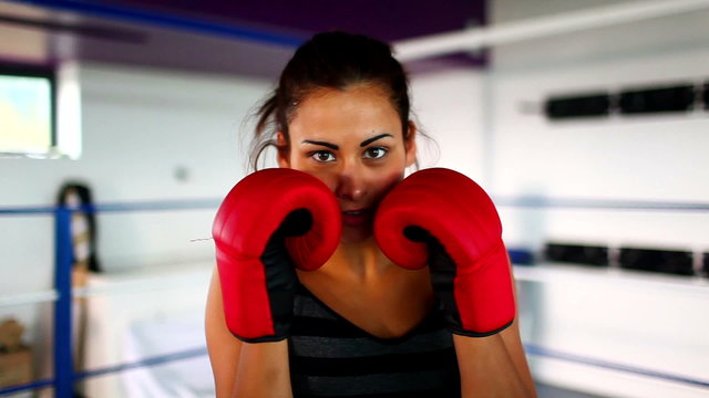 Aggressive fit woman wearing red boxing gloves boxing