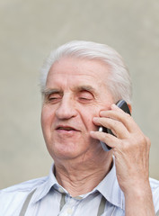 Senior man talks on cell phone and smiles