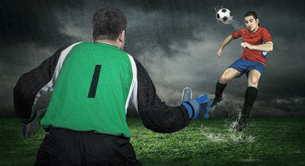 Two Football players in action under rain outdoors