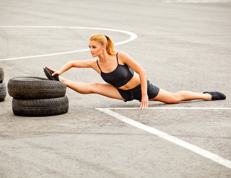 Portrait of Young Sporty Woman Doing Stretching Exercise. 