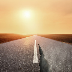 Driving on asphalt road at sunrise towards the sun