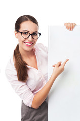 Naklejka premium Businesswoman pointing at blank poster