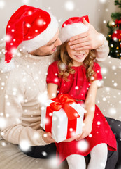 smiling father surprises daughter with gift box