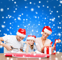 Fototapeta premium smiling family in santa helper hats with gift box