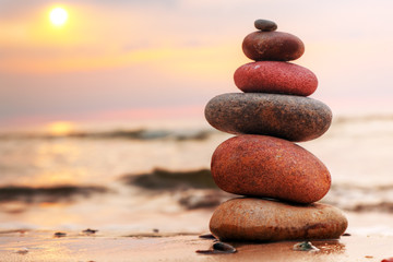 Stones pyramid on sand symbolizing zen, harmony, balance