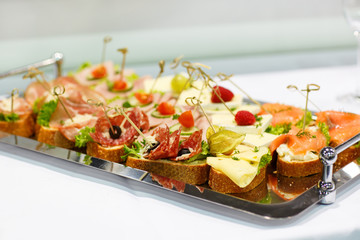 Different tasty snacks on luxury banquet table