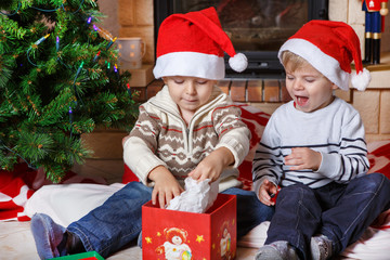 Two little sibling boys being happy about christmas present