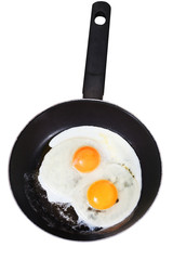 fried eggs in frying pan isolated on white